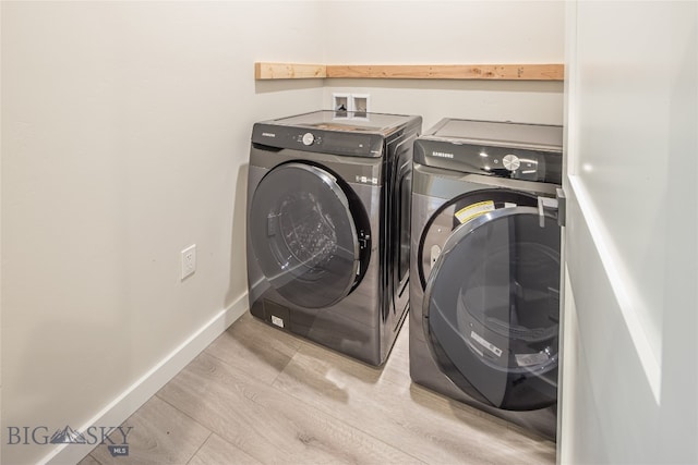 laundry room featuring separate washer and dryer, washer hookup, and light hardwood / wood-style floors