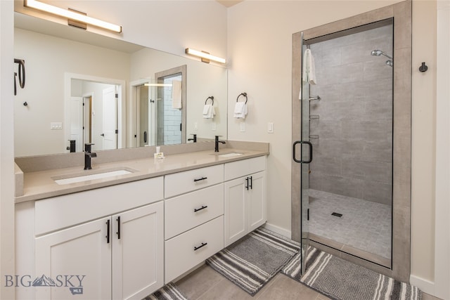 bathroom with tile floors, dual bowl vanity, and an enclosed shower