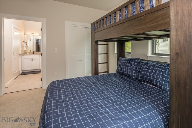 carpeted bedroom featuring sink, ensuite bathroom, and a closet