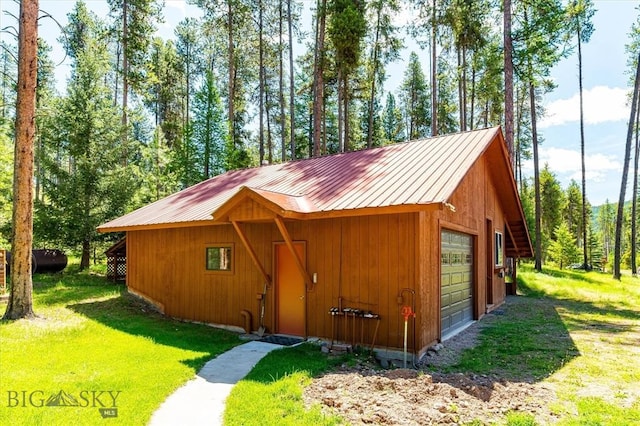 view of outdoor structure featuring a garage and a lawn