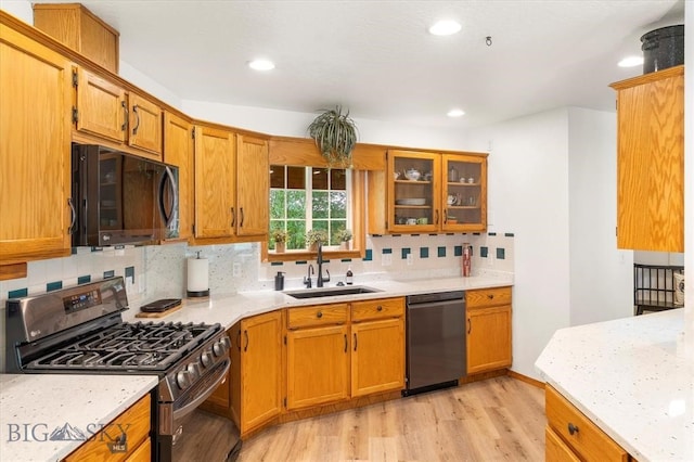 kitchen with backsplash, range with gas stovetop, dishwasher, and light hardwood / wood-style flooring