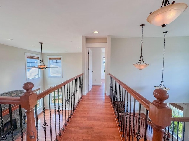 hall featuring light wood-style flooring, recessed lighting, an upstairs landing, and baseboards