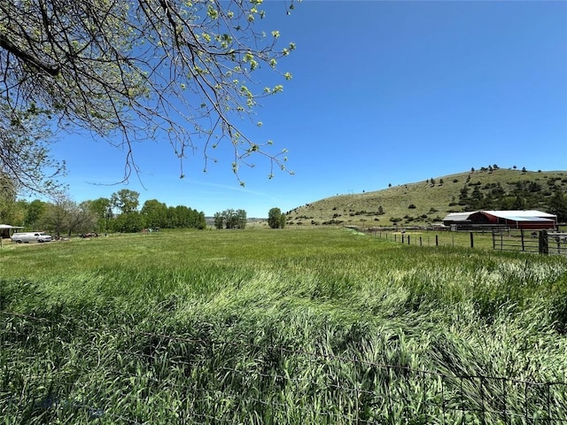 view of yard with a rural view and fence