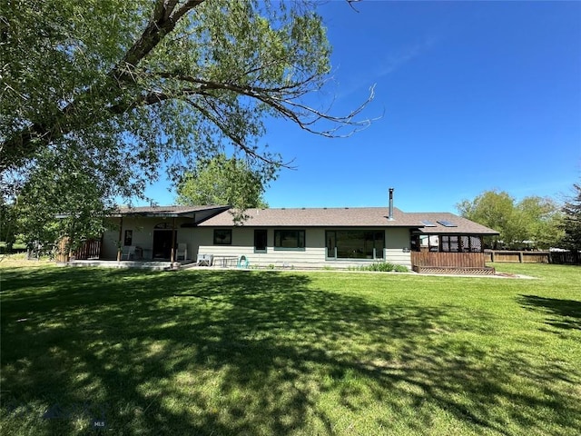 back of house featuring fence and a yard
