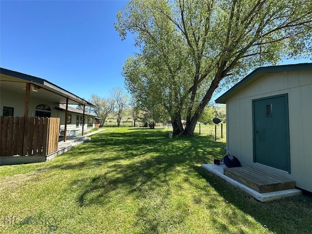 view of yard featuring fence and an outbuilding