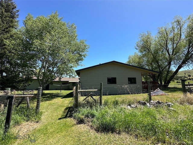 view of home's exterior with fence and a lawn