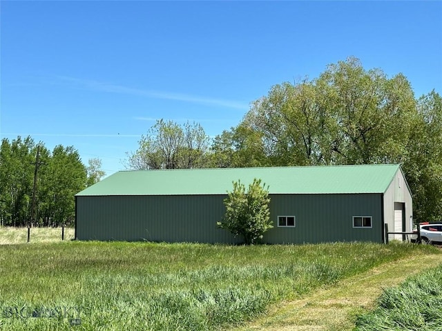 view of side of home with a garage, an outbuilding, and metal roof