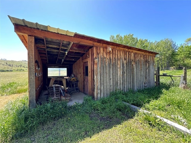 view of outbuilding featuring fence and an outbuilding