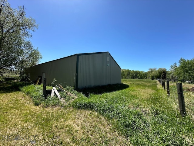 view of outbuilding featuring a yard and a rural view