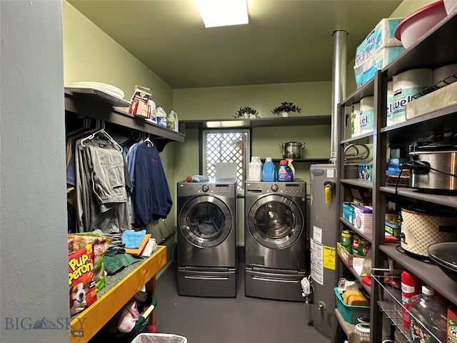 washroom with water heater and washing machine and dryer