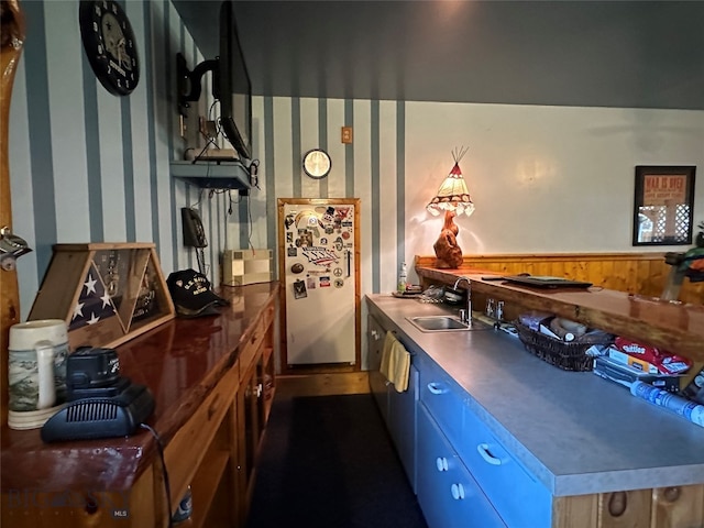 kitchen featuring refrigerator and sink