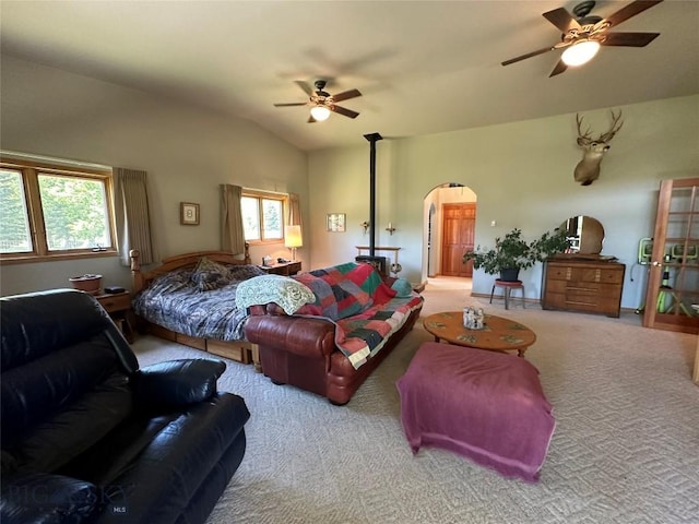 living room featuring a ceiling fan, arched walkways, lofted ceiling, and carpet flooring