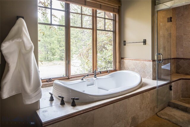 bathroom featuring tile patterned floors, a wealth of natural light, and separate shower and tub