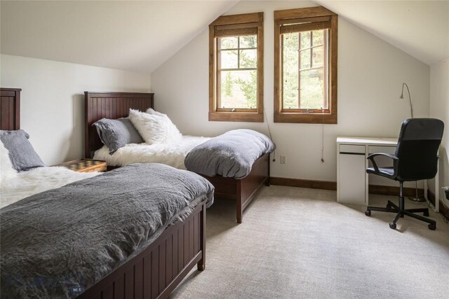 bedroom featuring lofted ceiling and light colored carpet