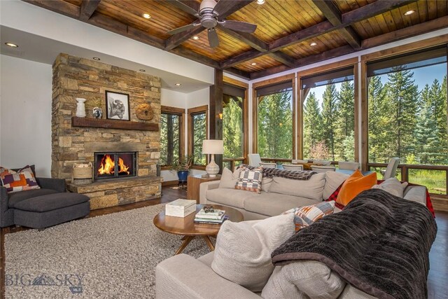 living room featuring hardwood / wood-style floors, ceiling fan, wooden ceiling, a fireplace, and beamed ceiling