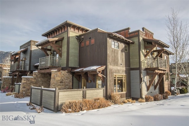 snow covered property with a balcony