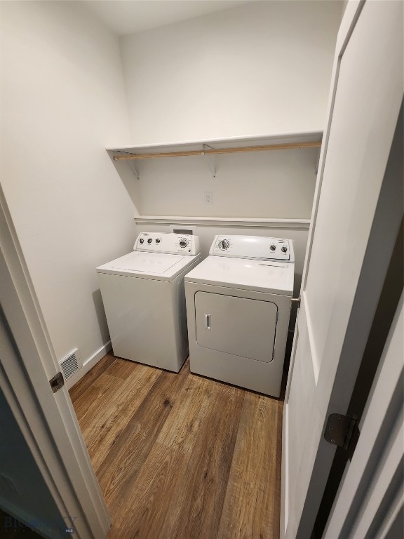 washroom featuring dark hardwood / wood-style flooring and washer and clothes dryer