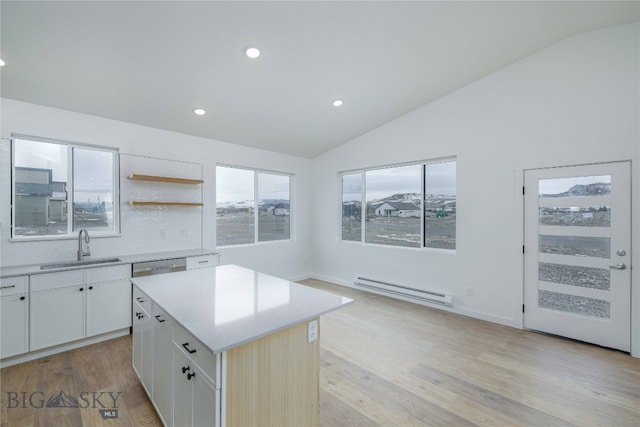 kitchen featuring a center island, light hardwood / wood-style floors, a baseboard radiator, sink, and vaulted ceiling