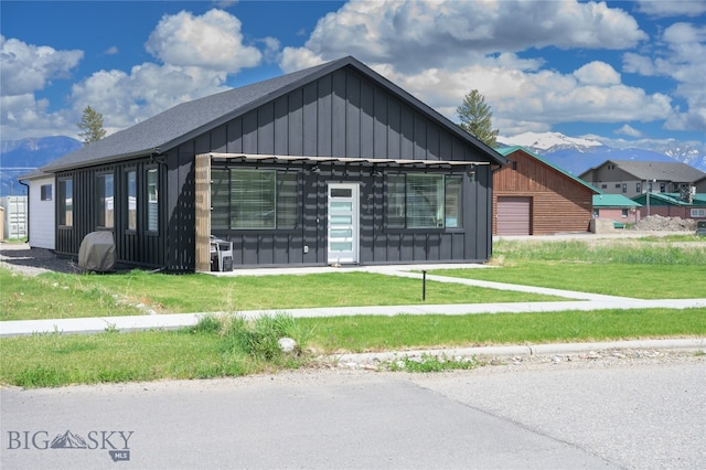 exterior space featuring a front yard, a garage, and a mountain view