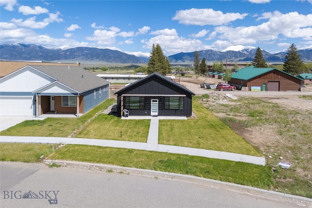 view of front facade featuring a front lawn and a mountain view