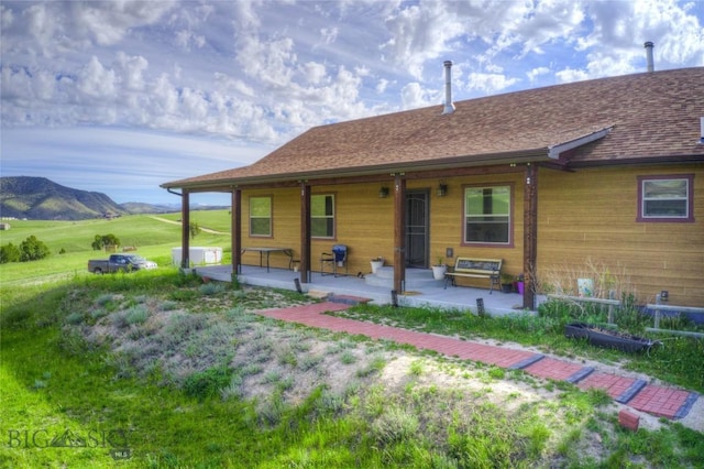 back of house with a mountain view and a patio area