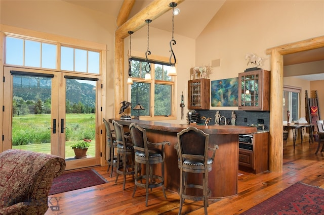 bar featuring french doors, backsplash, beam ceiling, high vaulted ceiling, and wood-type flooring