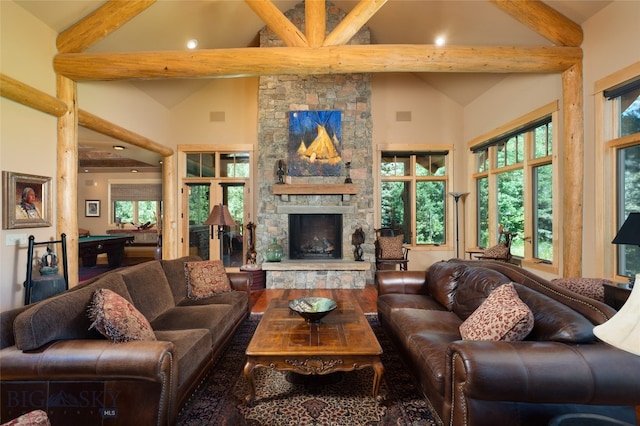 living room featuring plenty of natural light, a fireplace, and beamed ceiling