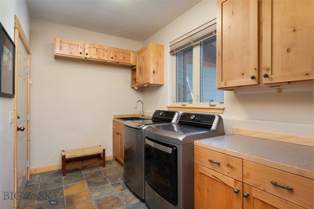 laundry room featuring cabinets, washer and dryer, sink, and dark tile patterned flooring