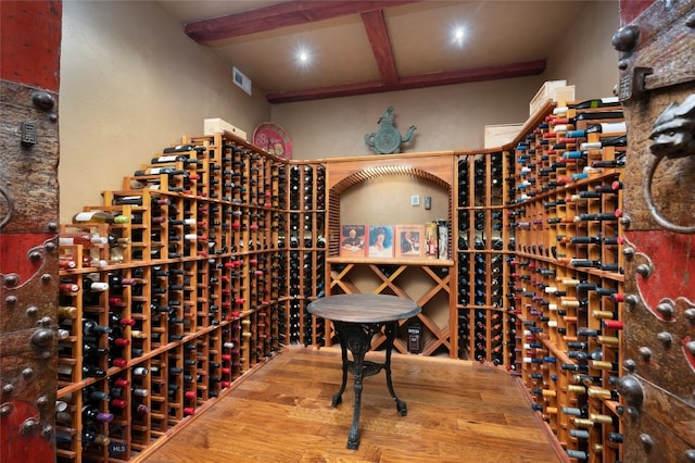 wine area with beam ceiling and wood-type flooring