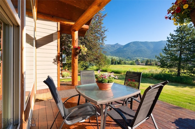 wooden terrace with a mountain view and a lawn