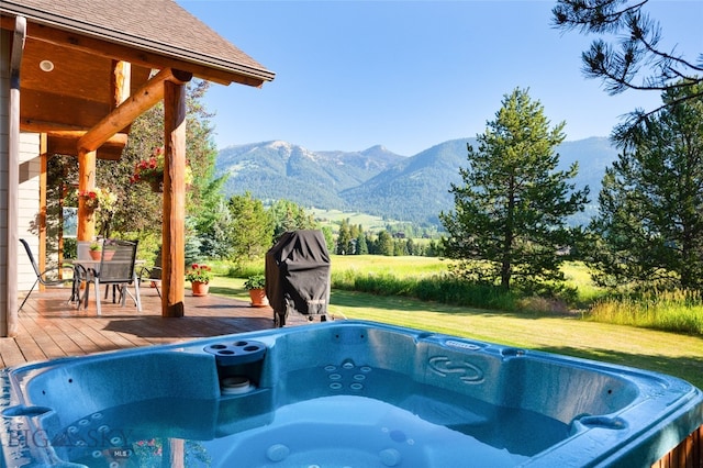 view of pool featuring a yard, a deck with mountain view, and a hot tub