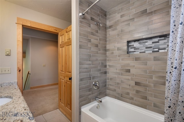 bathroom with tile patterned flooring, shower / bathtub combination with curtain, vanity, and a textured ceiling