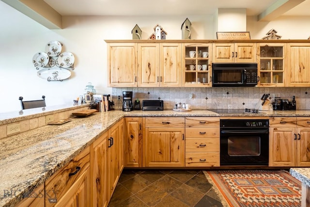 kitchen featuring light stone countertops, backsplash, and black appliances