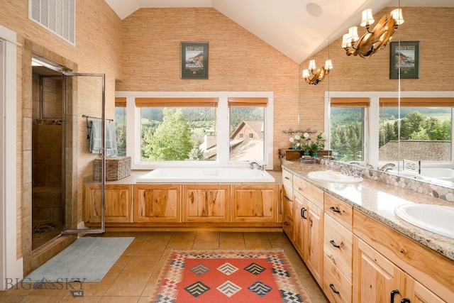 bathroom with tile patterned floors, vanity, vaulted ceiling, separate shower and tub, and an inviting chandelier