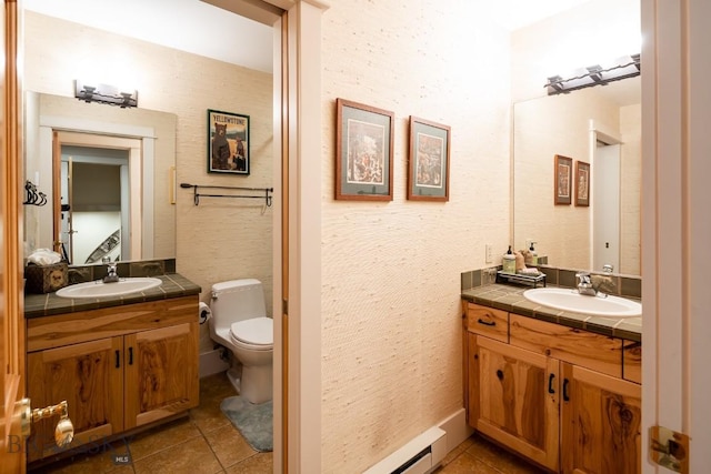 bathroom featuring toilet, vanity, a baseboard radiator, and tile patterned floors