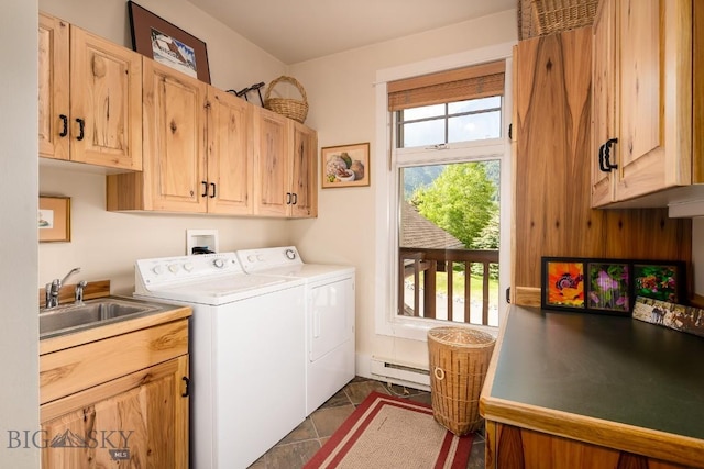 washroom featuring sink, cabinets, a baseboard radiator, washing machine and dryer, and dark tile patterned floors