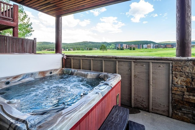 view of patio / terrace with a mountain view and a hot tub