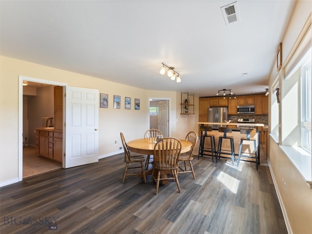 dining room with track lighting and dark hardwood / wood-style floors