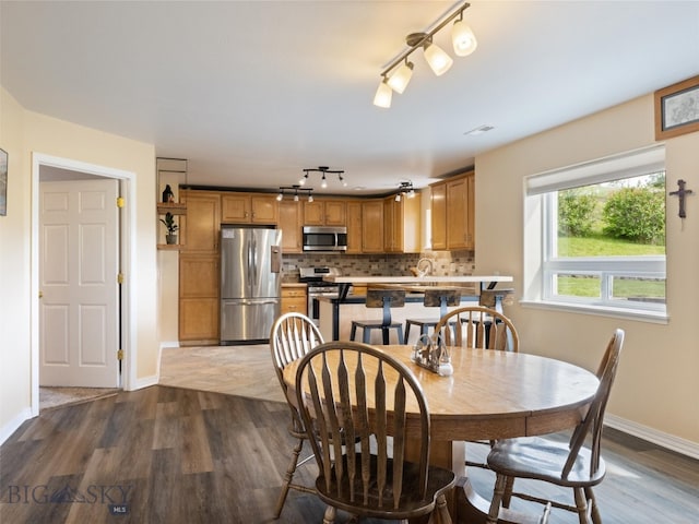 dining room featuring hardwood / wood-style flooring and rail lighting