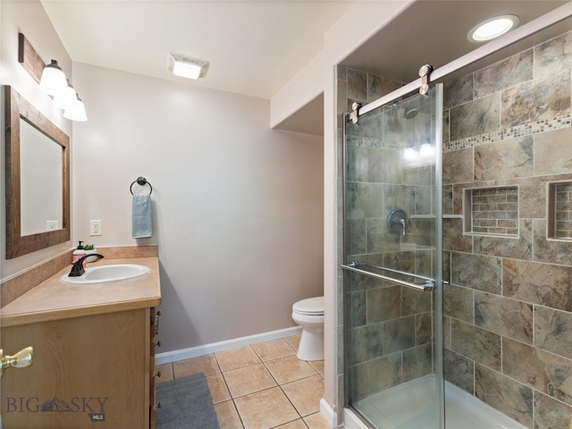 bathroom with tile floors, a shower with door, toilet, and oversized vanity