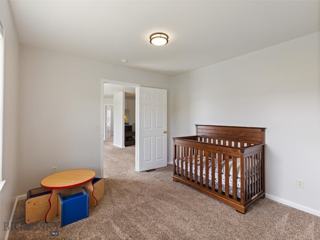 carpeted bedroom featuring a crib