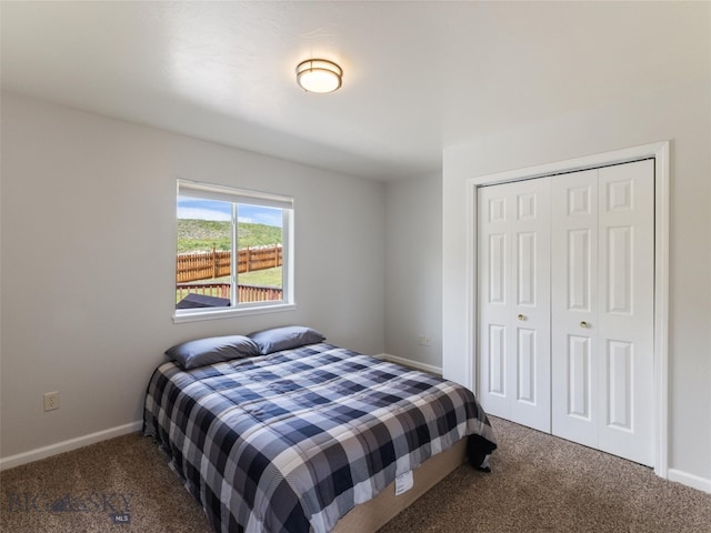 bedroom with dark colored carpet and a closet