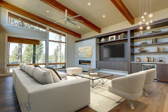 living room with a wealth of natural light, wood-type flooring, and a tile fireplace