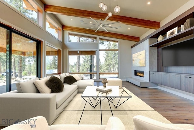 living room with a high ceiling, beamed ceiling, and light wood-type flooring