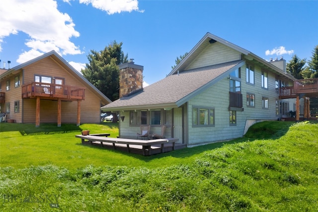 rear view of house featuring a yard and a wooden deck