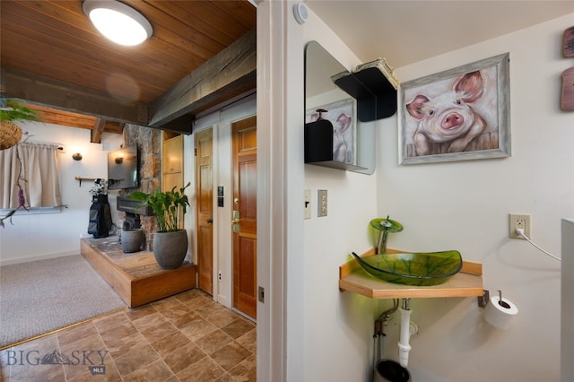 corridor with wooden ceiling, sink, and carpet floors