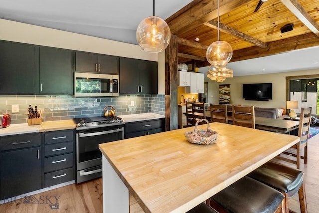 kitchen with pendant lighting, stainless steel appliances, beamed ceiling, tasteful backsplash, and wooden ceiling