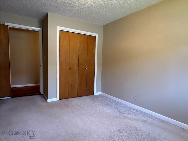 unfurnished bedroom featuring a closet, light colored carpet, and a textured ceiling