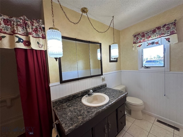 bathroom featuring tile patterned floors, vanity, a textured ceiling, and toilet