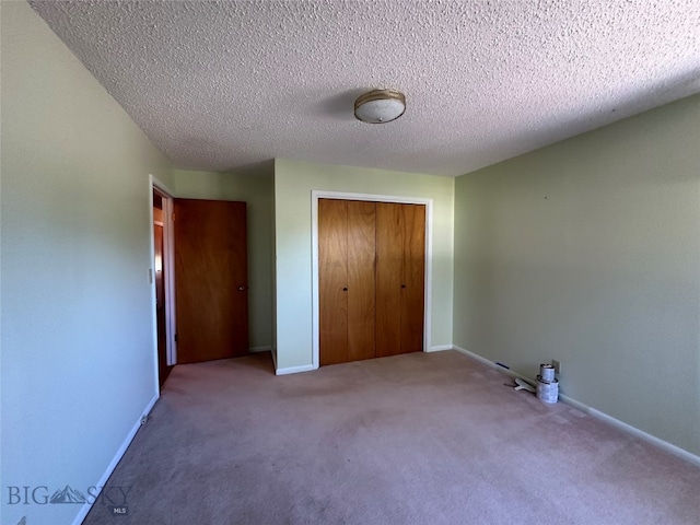 unfurnished bedroom with a closet, carpet, and a textured ceiling